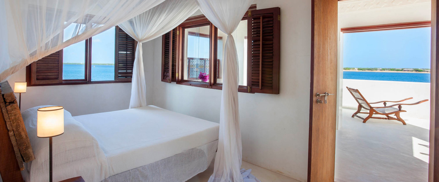 chambre de la villa à Shella Beach sur l’île de Lamu au Kenya avec lit à baldaquin et vue sur la mer