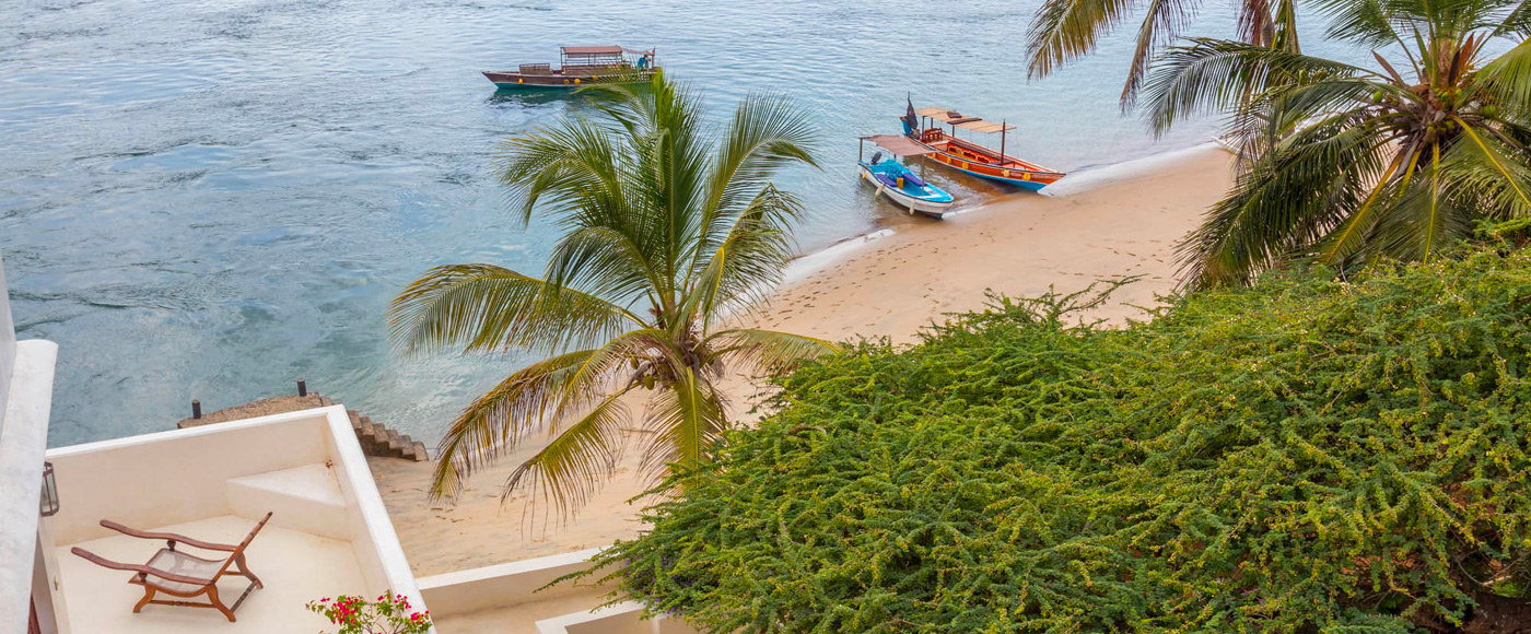 palm-lined beach at Shella Beach on Lamu Island in Kenya with fishing boats