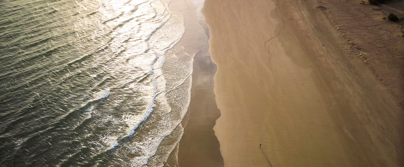 aerial view of the wild Shella beach on the coast of Lamu in Kenya with waves and golden sand