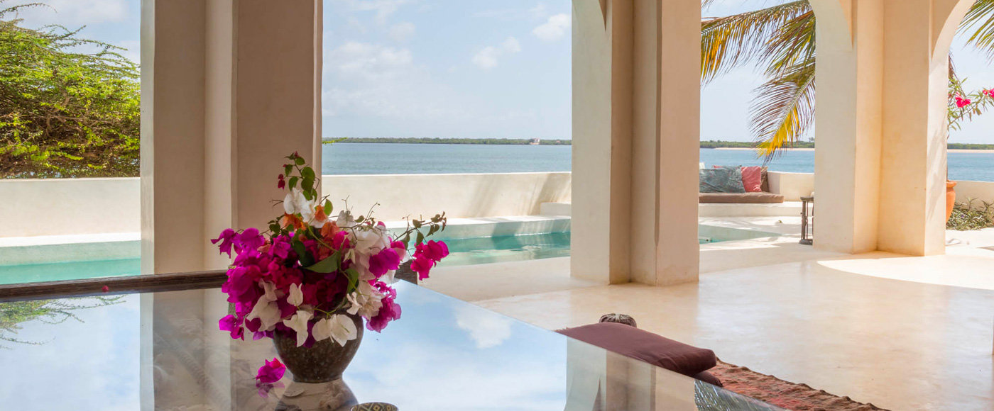 salon ouvert avec arches de la villa à Shella Beach sur l’île de Lamu au Kenya avec piscine et vue sur l’océan