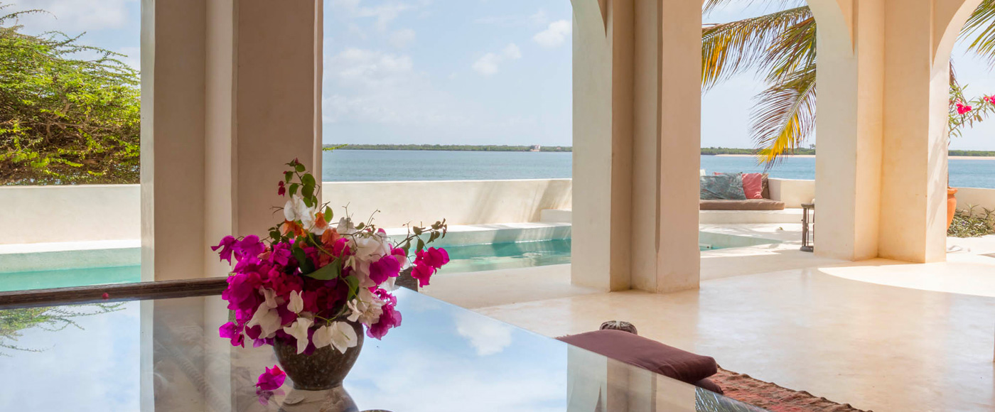 salon ouvert de la villa à Shella Beach sur l’île de Lamu au Kenya avec arches, piscine et vue sur l’océan indien