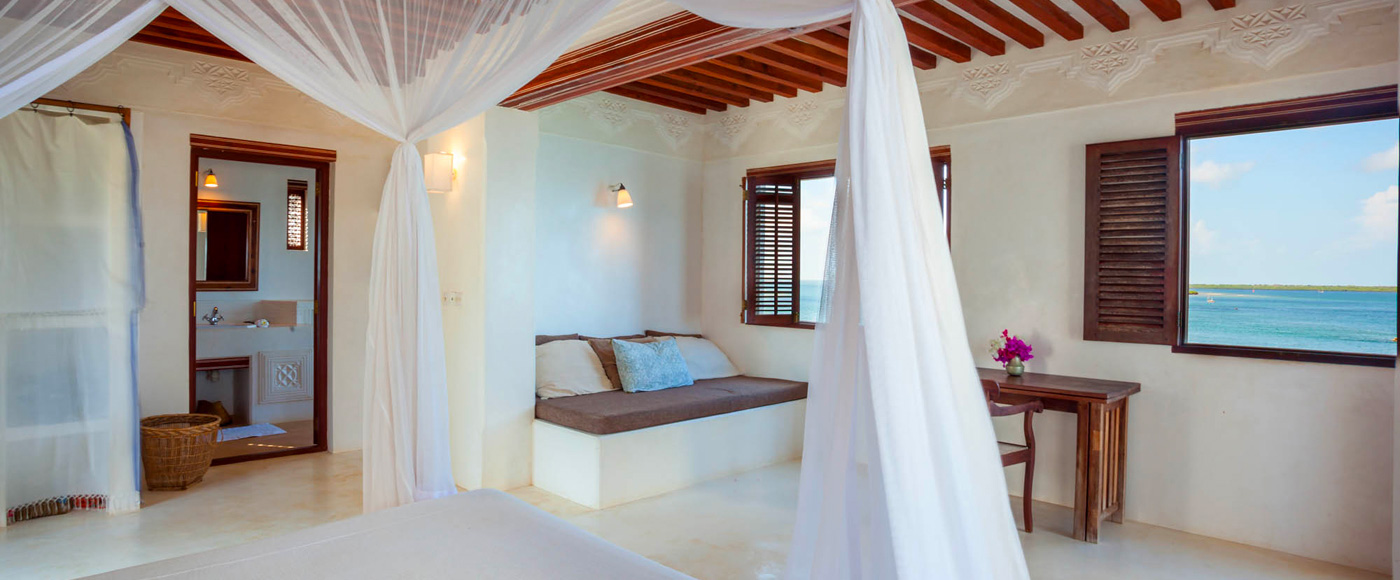 grande suite de la villa à Shella Beach sur l’île de Lamu au Kenya avec lit à baldaquin et vue sur la mer