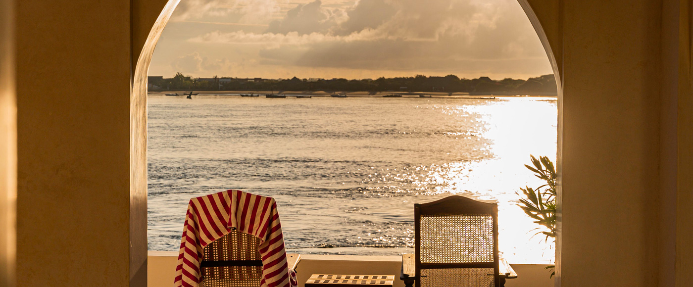 terrace of the villa in Shella Beach on Lamu Island in Kenya with armchairs facing the ocean at sunset