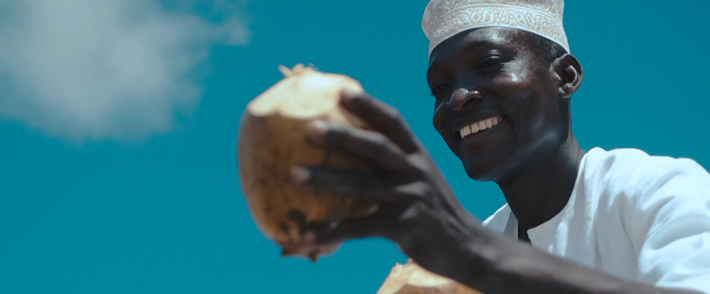 man carrying a coconut in Lamu, Kenya