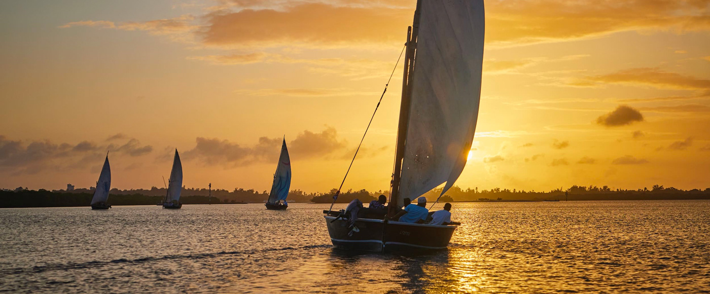 traditional sailboat sailing at sunset near Lamu Island in Kenya
